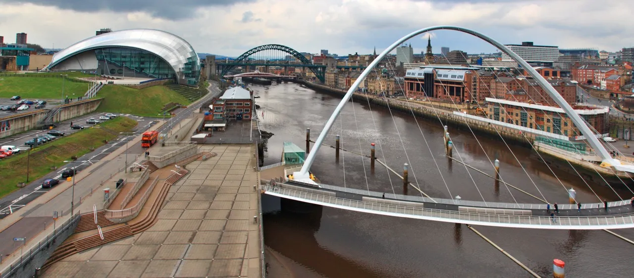 The Gateshead Millennium Bridge over the Tyne with the curved glass Sage building on the Gateshead bank