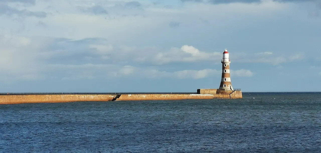 Roker Pier stretching out to its striped lighthouse across a calm blue sea