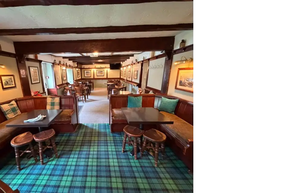 The beamed bar at the Cottage Inn near Craster, with tartan carpet, leather banquettes and wooden tables
