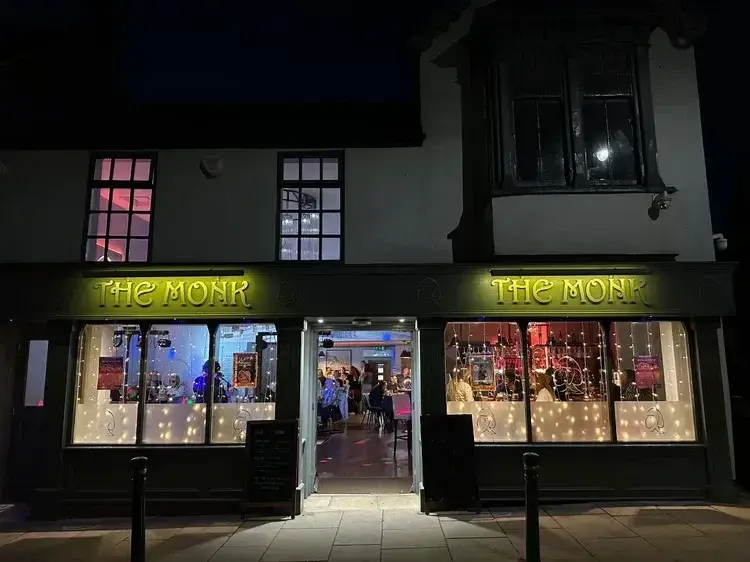 The Monk on Church Street, Guisborough at night, with its lit green sign and fairy lights in the windows